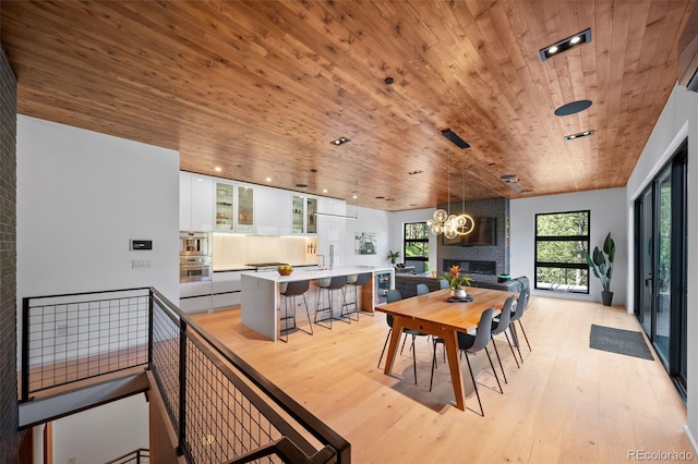365 Bow Mountain Rd, Boulder, CO 80302 - dining space featuring wooden ceiling, light wood-style flooring, a chandelier, and a fireplace