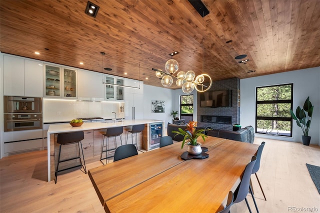 365 Bow Mountain Rd, Boulder, CO 80302 - dining area featuring wooden ceiling, light wood-type flooring, a chandelier, a brick fireplace, and lofted ceiling
