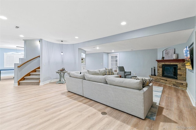 living area with recessed lighting, stairs, baseboards, and wood finished floors