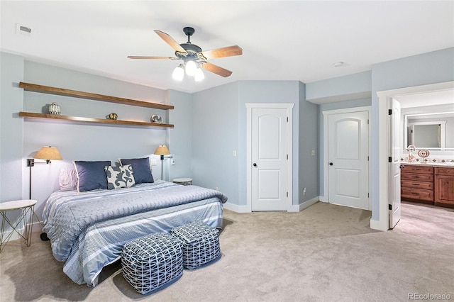 bedroom featuring a ceiling fan, visible vents, baseboards, ensuite bathroom, and light carpet