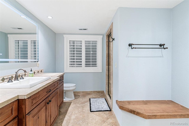 bathroom with visible vents, a shower stall, vanity, and toilet