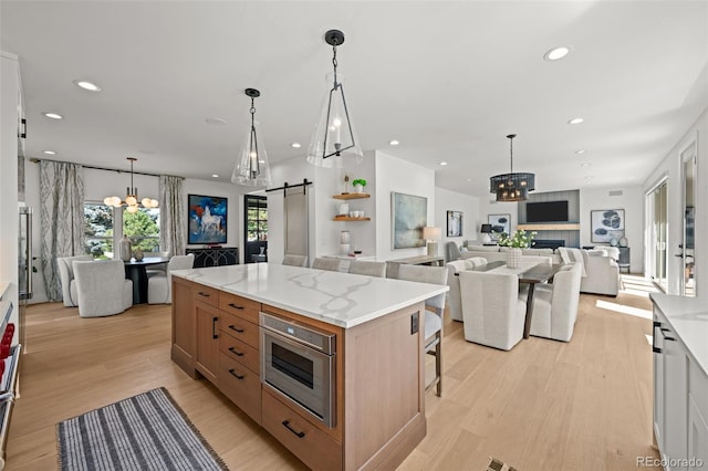 5698 Green Oaks Dr, Greenwood Village, CO 80121 - kitchen featuring a barn door, open floor plan, a chandelier, light wood-style flooring, and recessed lighting