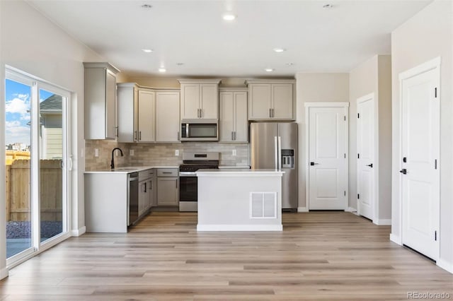 kitchen featuring gray cabinets, stainless steel appliances, visible vents, and light wood-type flooring