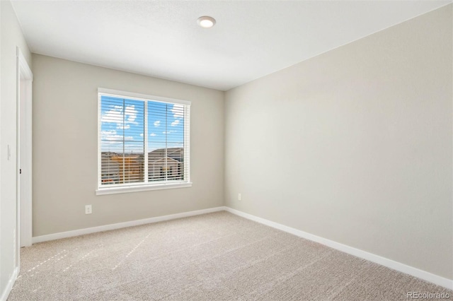 unfurnished room with light carpet and baseboards