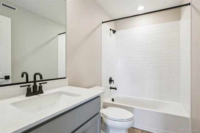bathroom with toilet, vanity, visible vents, and shower / tub combination