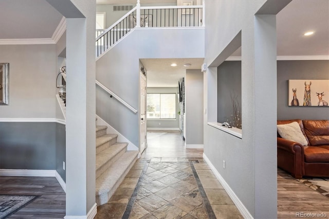 entrance foyer with crown molding and hardwood / wood-style flooring