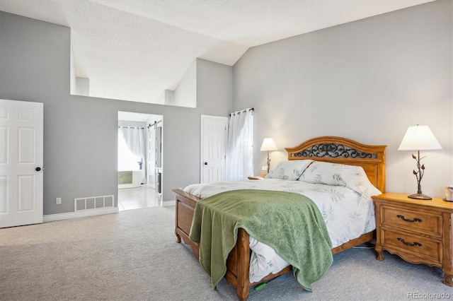 bedroom with connected bathroom, light carpet, a textured ceiling, and high vaulted ceiling