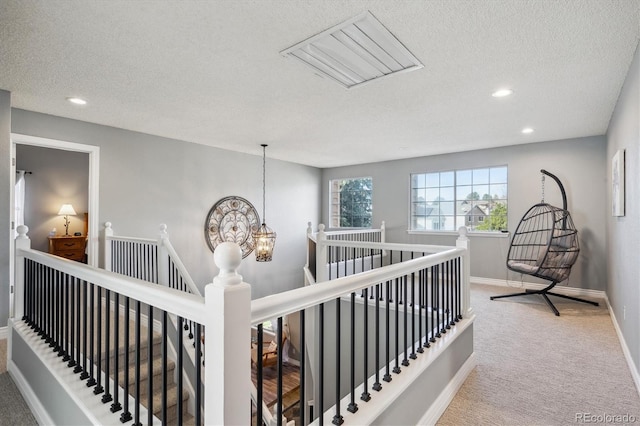 hallway featuring a textured ceiling and carpet flooring