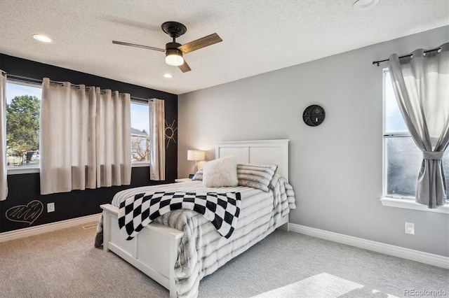 bedroom with light carpet, multiple windows, and ceiling fan