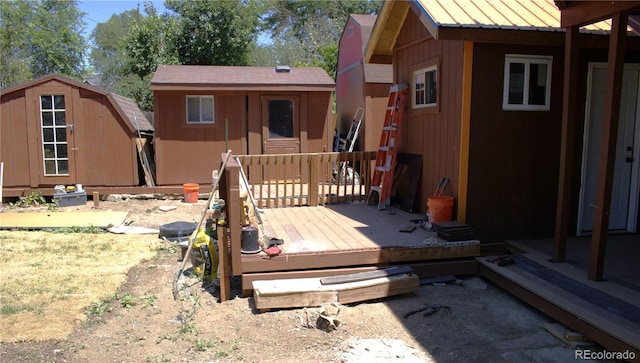 back of property with a wooden deck and a shed