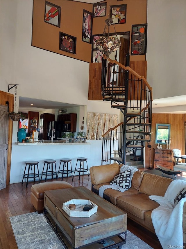 living room featuring hardwood / wood-style flooring and a towering ceiling