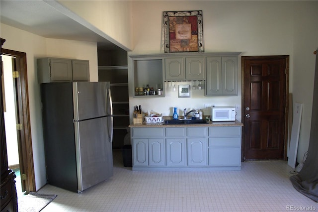 kitchen with sink, gray cabinetry, and stainless steel refrigerator