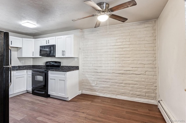 kitchen featuring white cabinetry, baseboard heating, brick wall, a textured ceiling, and black appliances