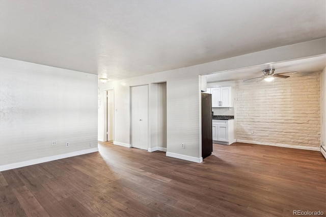 unfurnished living room with dark hardwood / wood-style flooring and ceiling fan