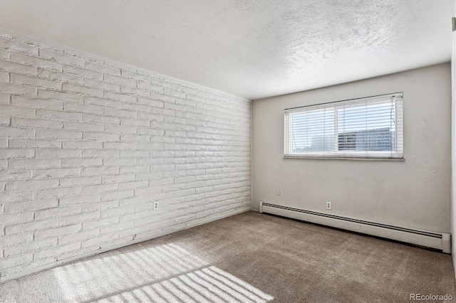 carpeted spare room with a textured ceiling, brick wall, and baseboard heating