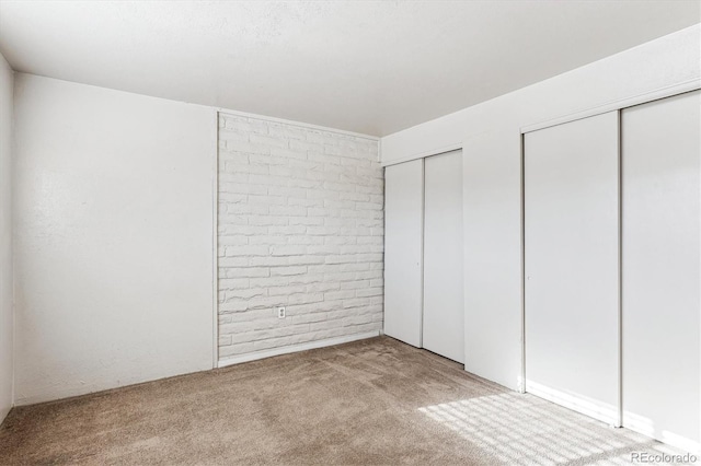 unfurnished bedroom with light carpet and two closets