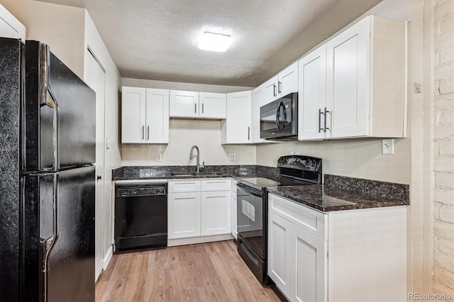 kitchen with white cabinets, sink, a textured ceiling, and black appliances