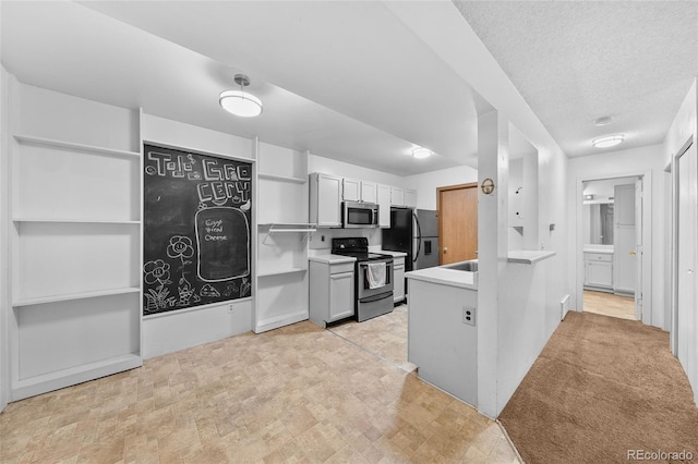 kitchen with open shelves, light countertops, a textured ceiling, and appliances with stainless steel finishes