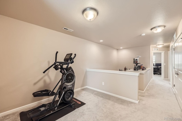 exercise room with light colored carpet