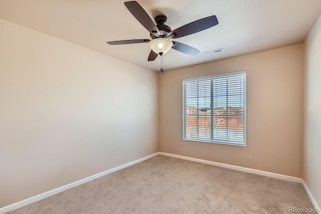 spare room featuring light carpet and ceiling fan