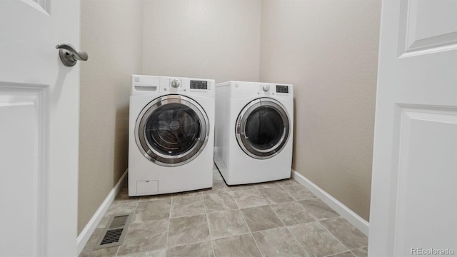 laundry area featuring laundry area, washing machine and dryer, baseboards, and visible vents