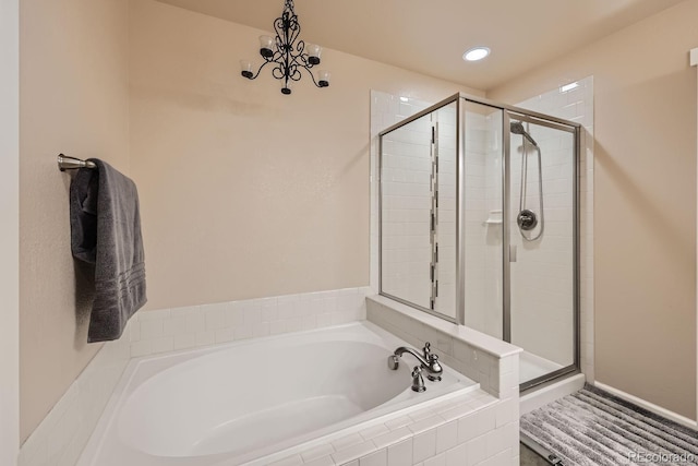 bathroom with a bath, a notable chandelier, recessed lighting, and a stall shower