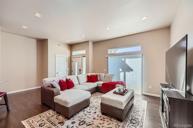 living area featuring visible vents, baseboards, and wood finished floors