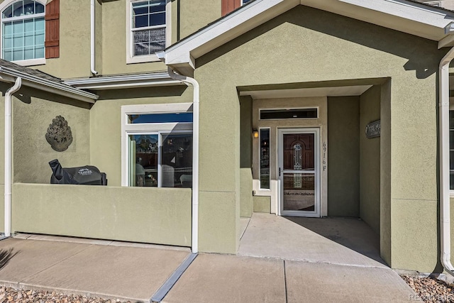 view of exterior entry featuring stucco siding