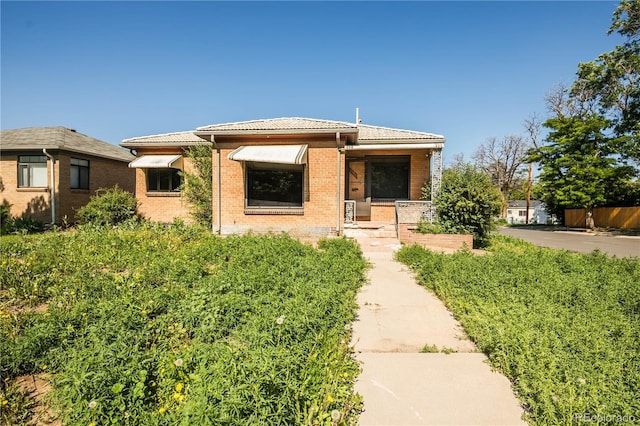 1195 Boston St, Aurora, CO 80010 - view of front of home featuring brick siding and a tiled roof