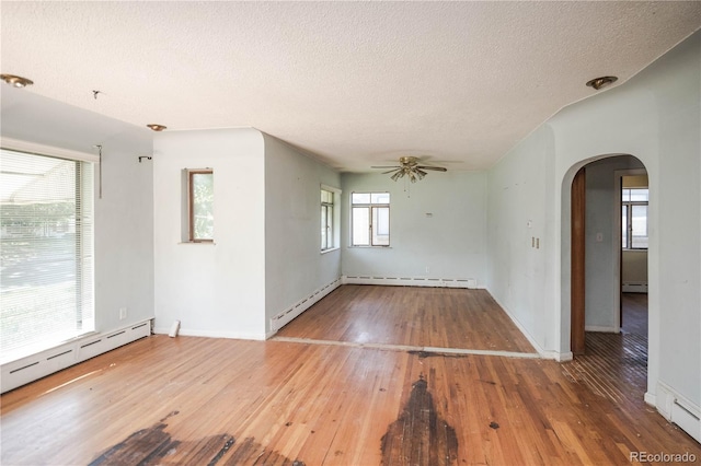 1195 Boston St, Aurora, CO 80010 - unfurnished room with arched walkways, a textured ceiling, hardwood / wood-style flooring, a baseboard radiator, and a ceiling fan