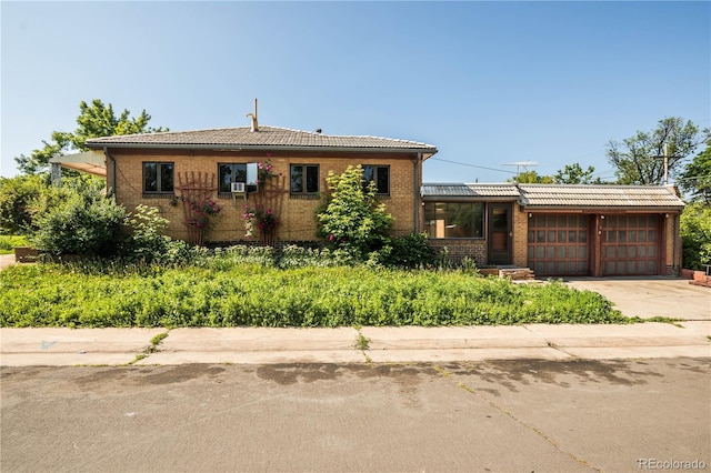 1195 Boston St, Aurora, CO 80010 - view of front of home with a garage, brick siding, driveway, and a tile roof