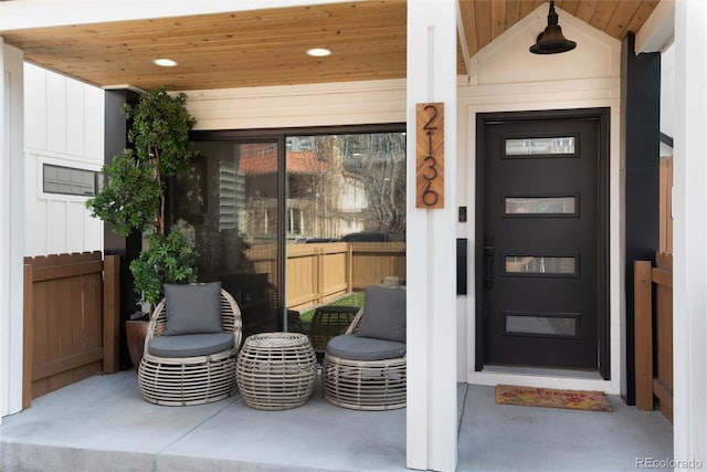 entrance to property with covered porch and fence