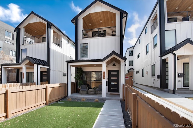 back of property featuring board and batten siding and fence