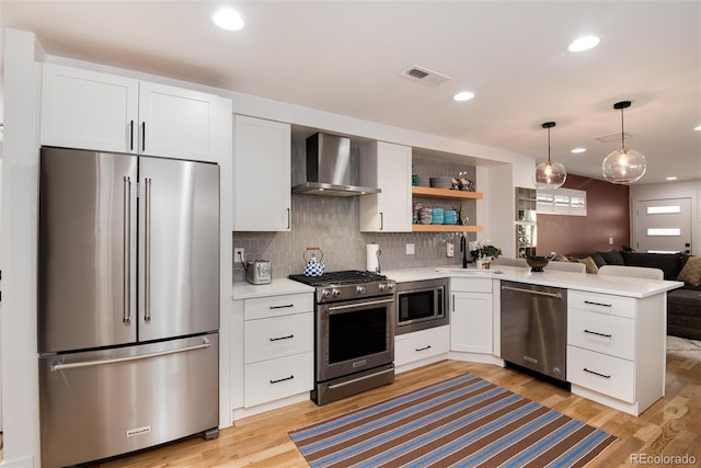 kitchen with white cabinetry, light countertops, wall chimney exhaust hood, and stainless steel appliances