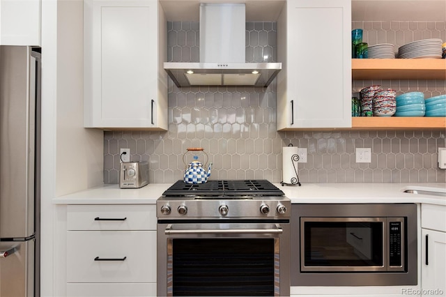 kitchen featuring white cabinetry, tasteful backsplash, appliances with stainless steel finishes, and wall chimney range hood