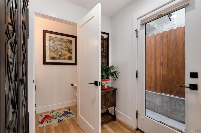 foyer with baseboards and light wood-style flooring