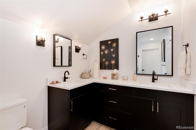 full bath with vaulted ceiling, toilet, double vanity, and a sink