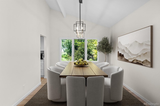 11241 E Cimmarron Dr, Englewood, CO 80111 - dining area featuring wood finished floors, vaulted ceiling, and a chandelier
