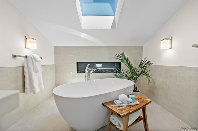 11241 E Cimmarron Dr, Englewood, CO 80111 - full bath featuring tile walls, a freestanding tub, a skylight, tile patterned floors, and a wainscoted wall