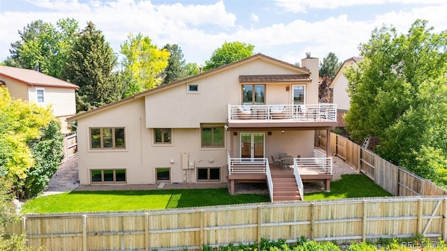 11241 E Cimmarron Dr, Englewood, CO 80111 - back of house featuring a balcony, a fenced backyard, stucco siding, and a deck