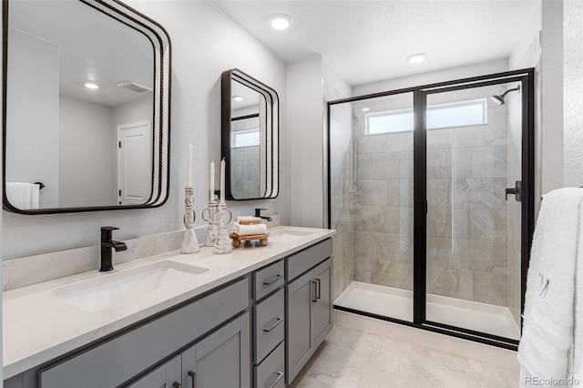 16498 W 92nd Pl, Arvada, CO 80007 - full bathroom featuring double vanity, a stall shower, marble look tiles, and recessed lighting