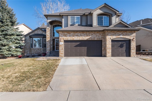 view of front facade featuring brick siding, a shingled roof, an attached garage, driveway, and a front lawn