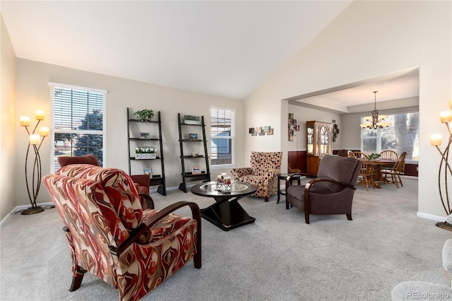 carpeted living room with vaulted ceiling, baseboards, and an inviting chandelier