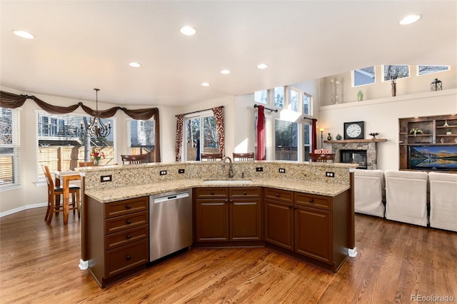 kitchen with dishwasher, wood finished floors, a sink, and a healthy amount of sunlight