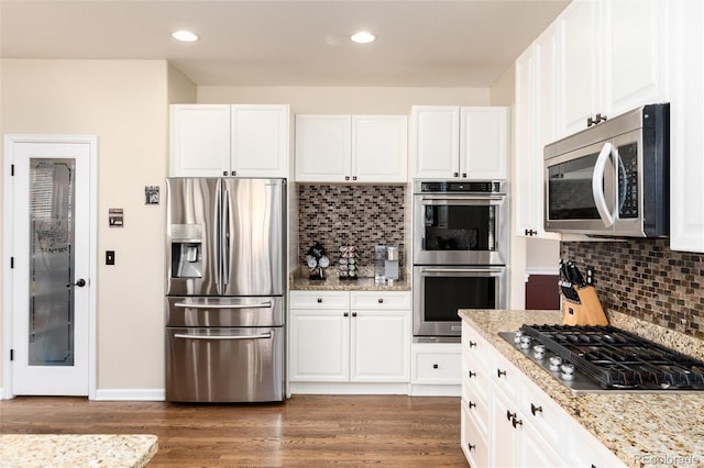 kitchen featuring white cabinets, appliances with stainless steel finishes, dark wood finished floors, and recessed lighting