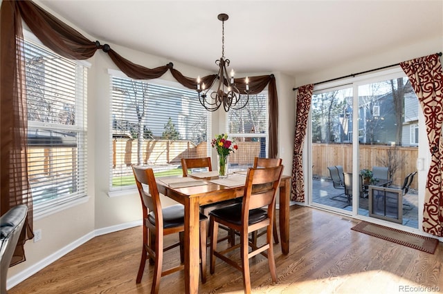 dining area featuring a chandelier, wood finished floors, and a wealth of natural light