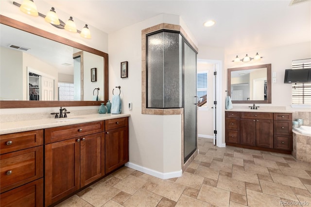 full bathroom featuring stone tile floors, two vanities, a sink, visible vents, and a stall shower