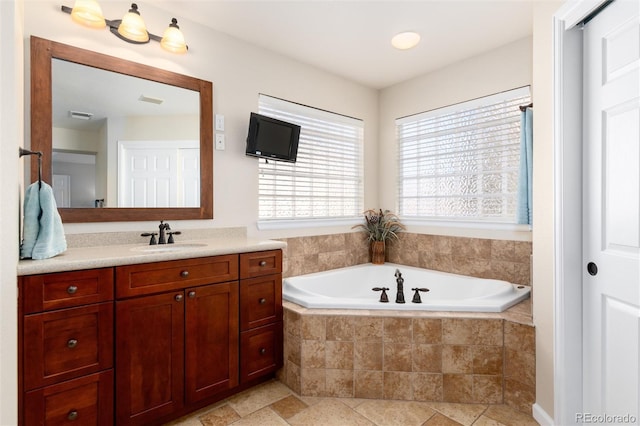 full bathroom with visible vents, a garden tub, and vanity