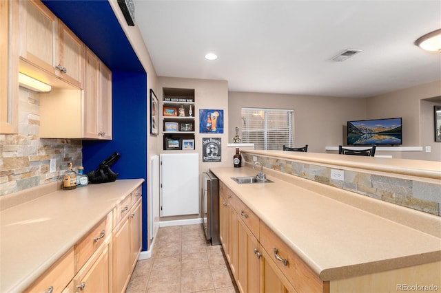 kitchen with light countertops, visible vents, a sink, and light brown cabinetry