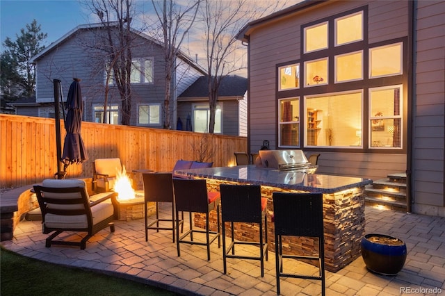 view of patio featuring fence, outdoor dry bar, and area for grilling